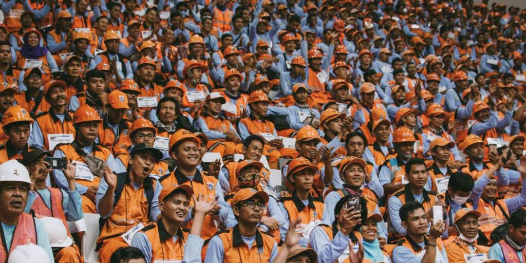 AI job loss image represented by a large group of blue collar workers.