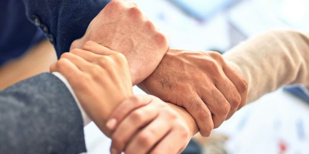 AI job loss image represented by humans linking arms in a sign of unity.