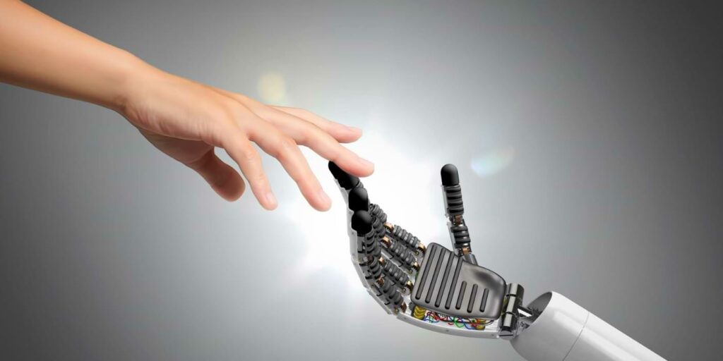 AI job displacement image featuring a human hand and a robot hand connecting