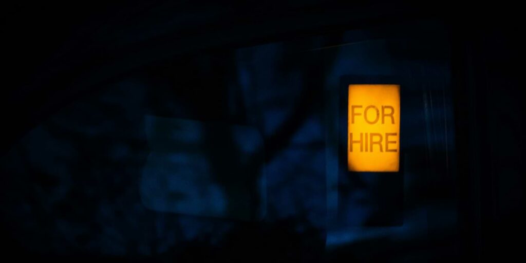 Forever layoffs image depicted by a "for hire" sign in darkness