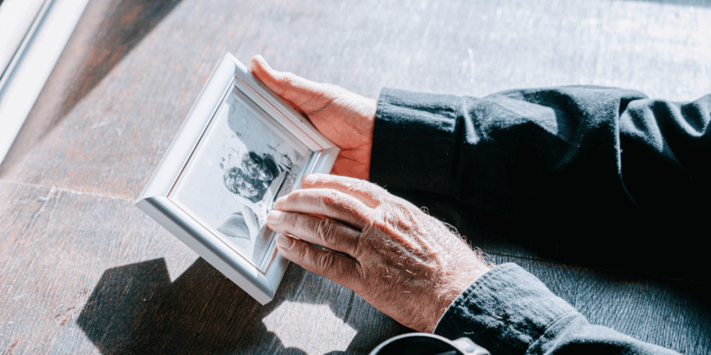 old person touching a black and white image used to represent memory