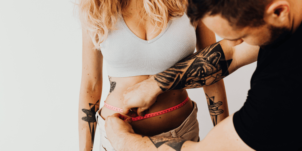 Female body standards shown by a man measuring a woman's waist